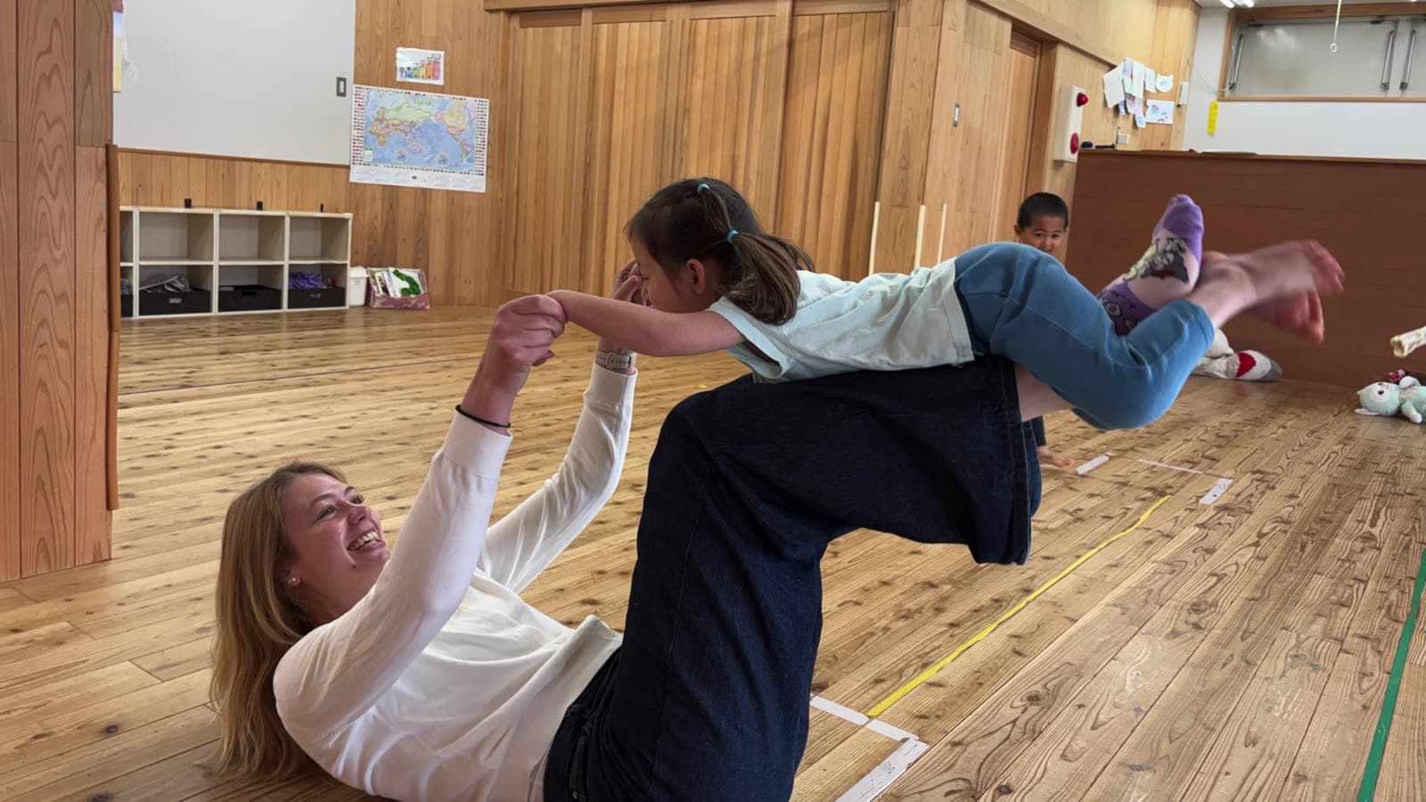 An intern playing an acrobatic game with a child indoors
