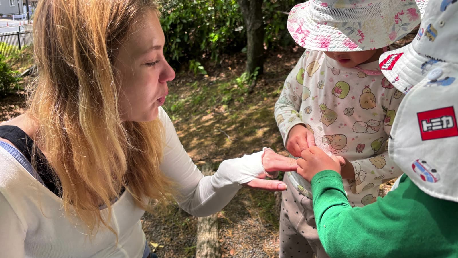 An intern looking at something in a child's hand outdoors